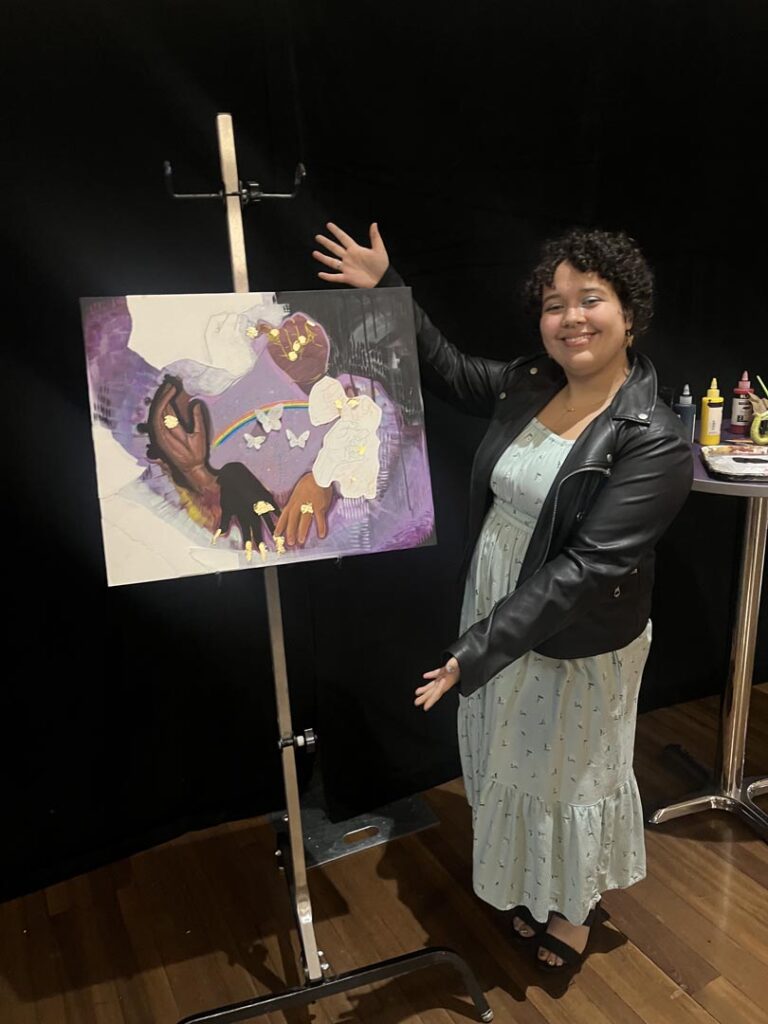 A picture of Ileana Kuran's piece Hands with her standing next to it